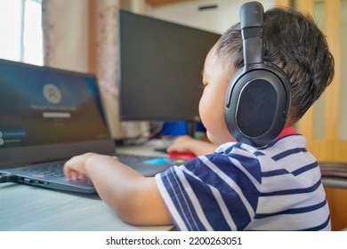 Homeschool, e-learning, self learning concept. An Asian boy student using personal computer to learn and searching information on internet. Covid 19 Social Distance, E-learning online education.