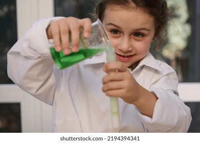 Homeschooling Caucasian little girl in white lab coat learning about science, pouring reagent solution from flask into a test tube, watching fascination going on chemical reaction. Learning - Shutterstock ID 2194394341