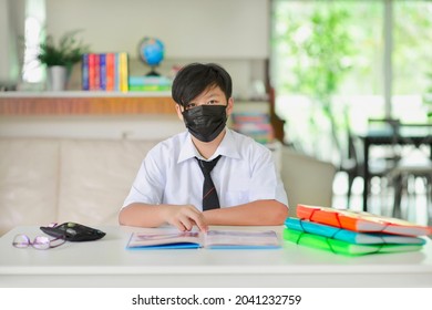 Homeschooling Malaysian Secondary School Student With Facemask Studying At Home During Pandemic.Asian Child Doing Lesson In Tuition Centre In Malaysia.Education In Asia.Kid With Open Book On Desk.