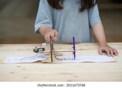 Homeschooling And Seismograph.Child Learning Seismic Technology.Homeschool Student With Earthquake Warning Equipment Sample.Wooden Science And Engineering DIY Craft.Girl Studying Geography.