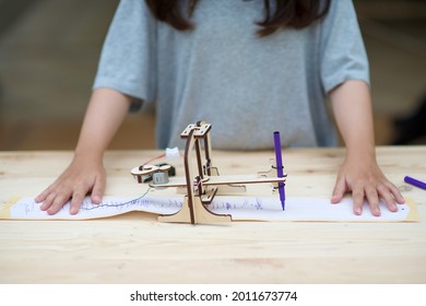 Homeschooling And Seismograph.Child Learning Seismic Technology.Homeschool Student With Earthquake Warning Equipment Sample.Wooden Science And Engineering DIY Craft.Girl Studying Geography.