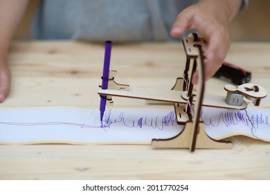 Homeschooling And Seismograph.Child Learning Seismic Technology.Homeschool Student With Earthquake Warning Equipment Sample.Wooden Science And Engineering DIY Craft.Girl Studying Geography.