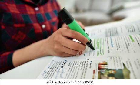 Homework. Cropped shot of a female student learning English, studying at home. Making some notes in textbook. E-learning. Focus on hand. Distance education. Learning foreign languages online. Covid 19 - Shutterstock ID 1770290906