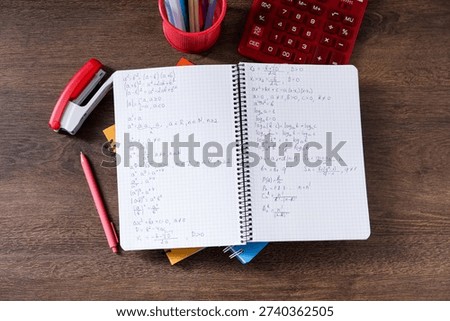 Homework. Notebook with math formulas and different stationery on wooden table, flat lay