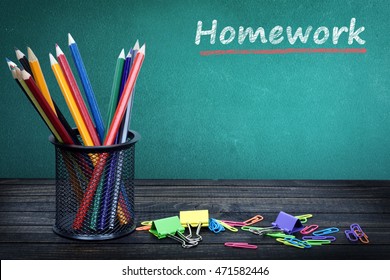Homework text on green board and group of pencils - Shutterstock ID 471582446