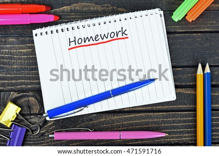 Homework text on notepad and office tools on wooden table