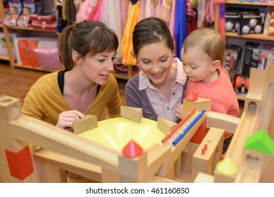 Homosexual Couple And Daughter Shopping In Toy Store