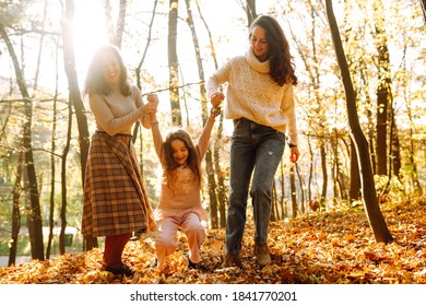 The Homosexual Family Having Fun With Her Daughter In The Autumn Forest. Rest On Autumn Park.