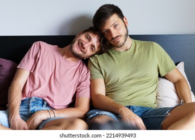 Homosexual Male Couple Sitting On The Bed While Looking At Camera - LGBT Concept