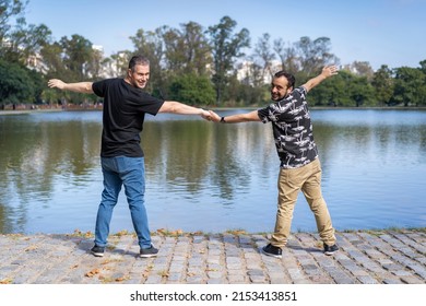 Homosexual Mature White Male Couple Holding Hands Smiling At A Lake