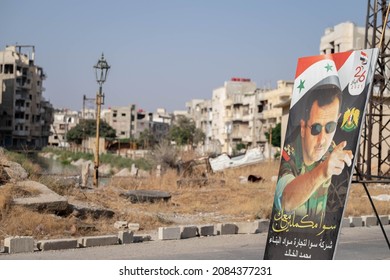 Homs, Syria - August 25, 2021: Poster of Bashar al-Assad in destroyed city center after Syria war.