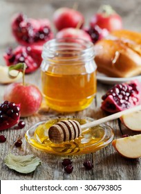 Honey, apple, pomegranate and hala, table set with traditional food for Jewish New Year Holiday, Rosh Hashana