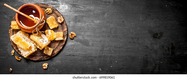Honey background. Fresh honey in the pot with the nuts. On a black chalkboard. - Shutterstock ID 699819061