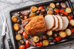 Honey Baked Pork Loin With Potatoes, Onions, Bell Peppers And Mushrooms Close-up On A Baking Sheet On The Table. Horizontal Top View From Above
