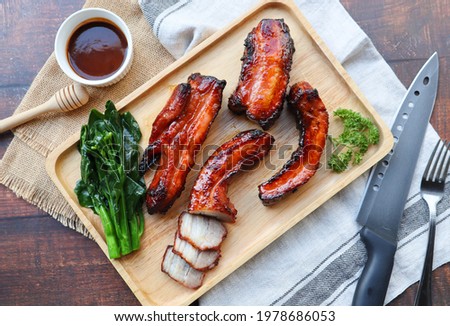 Honey barbecue roast pork on wood tray of wood table - Chinese style grilled pork called Char Siu pork