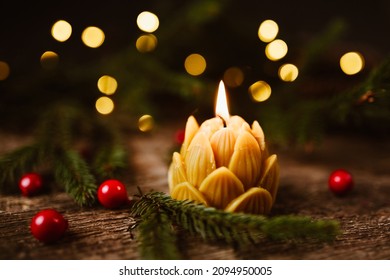 Honey bee natural wax candle with fire in a Christmas holiday decoration on a wood background. - Shutterstock ID 2094950005