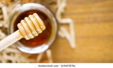 Honey Dipper With Glass Jar And Wood Background. Top View Shot With Copy Space. Health And Beauty Product Sustainable Lifestyle Concept.