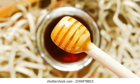 Honey Dipper With Honey On Wood Background With Paper Shreds. Close Up Macro Shot. Health And Beauty Product Sustainable Lifestyle Concept. 