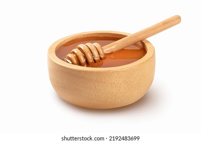 Honey with honey dipper in wooden bowl isolated on white background.