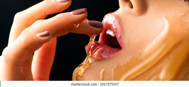 Honey dripping on sexy girl lips. Eating honey. Beauty model woman open mouth, model eating nectar. Healthy food concept, diet, dessert