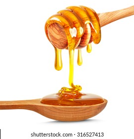 Honey Dripping On The Wooden Spoon Isolated On White