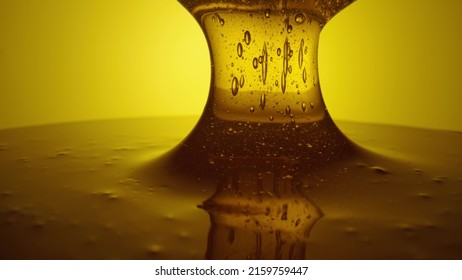 Honey dripping, pouring from spoon. Thick viscous honey molasses dripping. Close up of golden honey liquid, sweet product of beekeeping. Sugar syrup is pouring. Healthy and curative dessert.