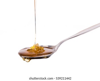 Honey dripping from a spoon isolated on white background - Shutterstock ID 539211442