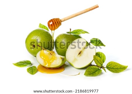 Honey dripping from wooden stick on green apples. White background. Rosh Hashanah (Jewish New Year holiday) concept.