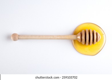 Honey Flowing Down From A Wooden Stick Isolated On White  Background