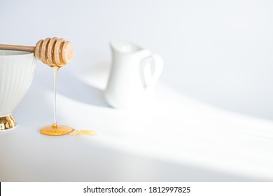 Honey flowing from turfed honey stick. honeys do on white background. Breakfast cream jug - Powered by Shutterstock