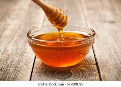 Honey in glass bowl on wooden table