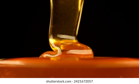 Honey. Golden Thick Honey Dripping close up. Pouring honey isolated on black background - Powered by Shutterstock