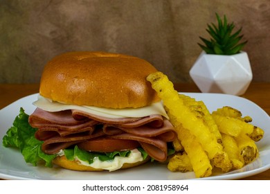 Honey Ham On A Bun Top With Provolone Cheese, And Served With A Side Of Fries