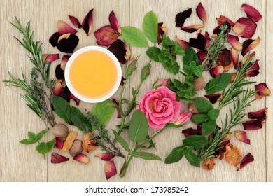 Honey, Herb And Rose Flower Ingredients For Magical Love Potions Over Oak Wood  Background.