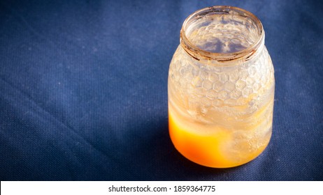 Honey Jar Almost Empty On Blue Tablecloth