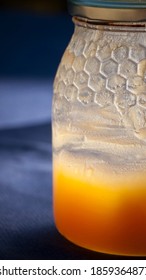 Honey Jar Almost Empty On Blue Tablecloth