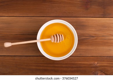 Honey In The Jar With A Spoon On A Wooden Table. Top View .