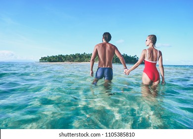 Honey moon on the sea shore. Back view of loving couple bathing together on beautiful tropical island beach. - Powered by Shutterstock