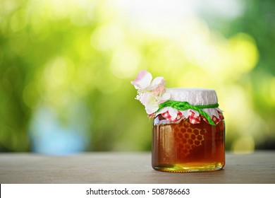 Honey from nature pollen flower  in glass bottle with green background.             