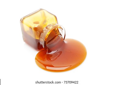 Honey Spill From A Glass Jar Isolated On White