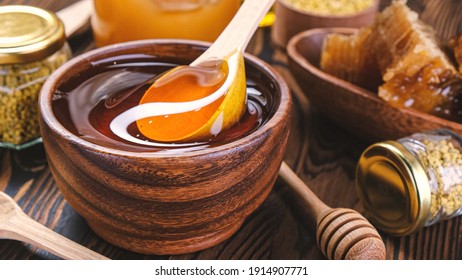 Honey With Spoon Over Wooden Background With Honeycomb And Propolis, Liquid Sugar Syrup, Flower Nectar