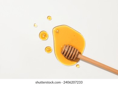 Honey and a wooden honey drizzle displayed on a white background. Vitamin C and antioxidants in honey help protect the skin from the effects of the sun. - Powered by Shutterstock