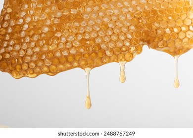 Honeycomb dripping with golden honey on a white background. Close-up shot highlighting the texture and natural beauty of honeycomb. Perfect for themes related to beekeeping, natural food, and organic. - Powered by Shutterstock