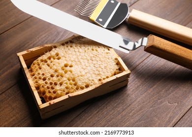 Honeycomb Frame And Beekeeping Tools On Wooden Table, Closeup