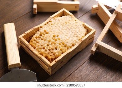 Honeycomb Frame And Beekeeping Tools On Wooden Table, Closeup