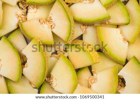 Honeydew melon slices, full frame food background, top view.