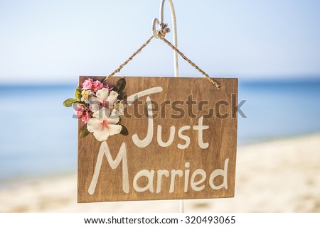 Honeymoon concept. Just married. Wooden plate on the tropical beach.