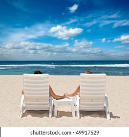 Honeymoon couple sunbathing in beach chairs