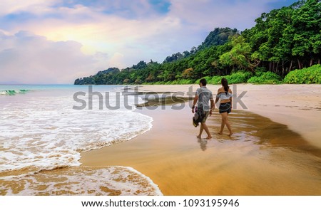 Honeymoon couple take a walk at the scenic Havelock islands beach at Andaman India.