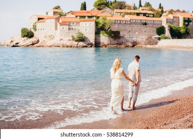 Honeymoon Couple Travel Sea And Beach Resort In Europe. Back View. Sea And Beach Side In Montenegro